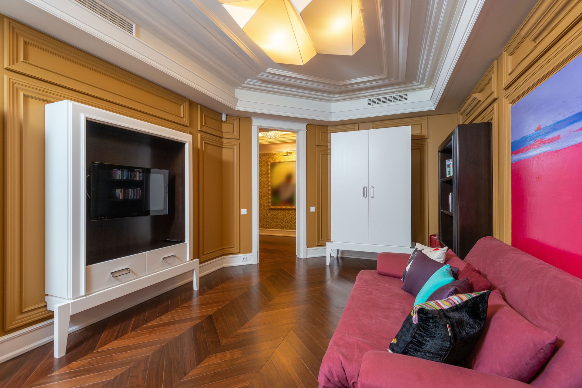 Spacious, cozy living room with modern decor, wooden floors, and vibrant accents.